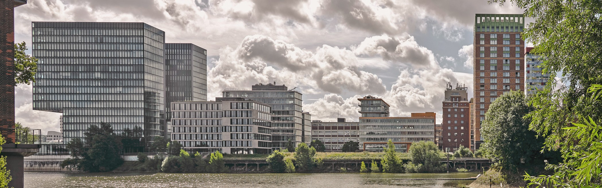 Panorama des Medienhafens Düsseldorf mit moderner Skyline und den WIN WIN Türmen am rechten Bildrand, gesehen vom Hafenbecken aus.