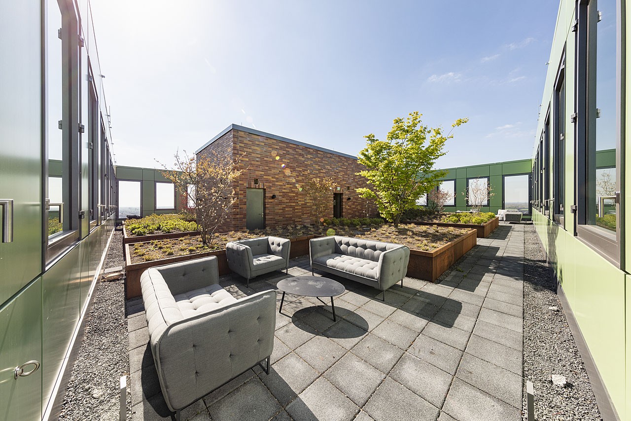 Roof terrace with lounge furniture and planted beds at WIN WIN Medienhafen Düsseldorf