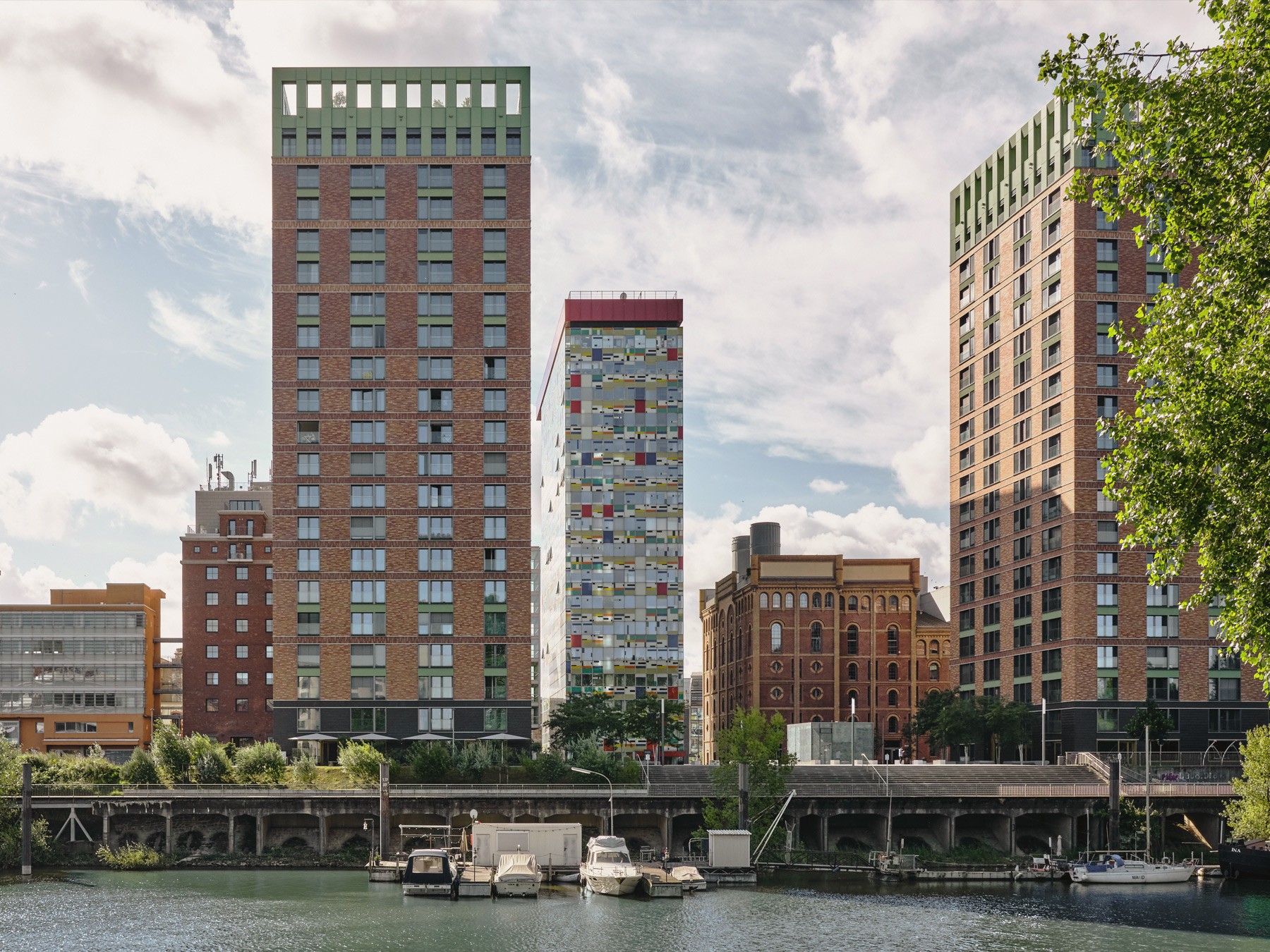 Blick auf die WIN WIN Türme im Medienhafen Düsseldorf mit dem farbigen Colorium-Turm und dem Hafenbecken im Vordergrund.
