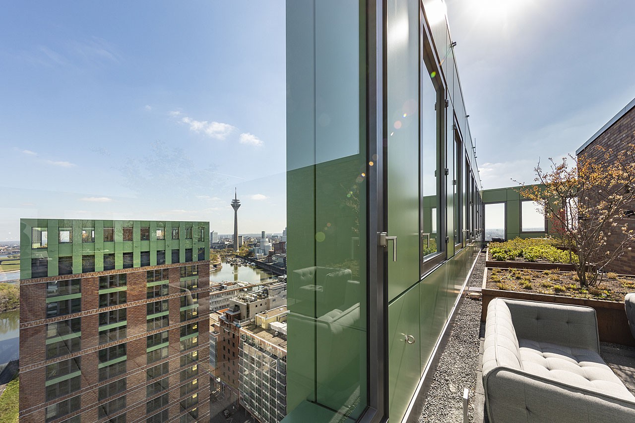 Blick von der WIN WIN Dachterrasse über den Medienhafen Düsseldorf mit Panorama auf den Rheinturm und die umliegenden Gebäude.