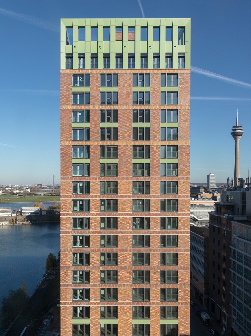 Frontale Ansicht eines WIN WIN Turms im Medienhafen Düsseldorf mit Blick auf das Hafenbecken und den Rheinturm im Hintergrund.