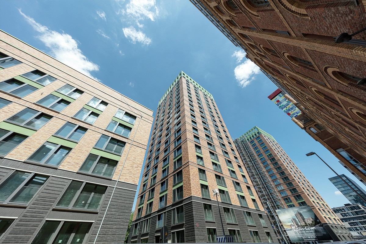 Aufsicht zwischen den Gebäuden mit Blick auf die WIN WIN Türme im Medienhafen Düsseldorf aus einer markanten Straßenperspektive.