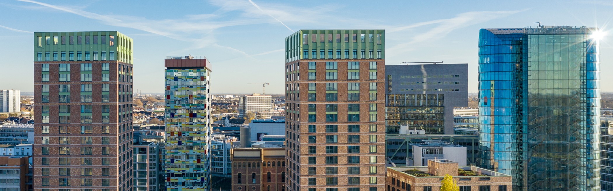 Luftaufnahme der WIN WIN Türme im Medienhafen Düsseldorf mit dem farbigen Colorium-Turm und dem markanten Glasturm im rechten Bildbereich.