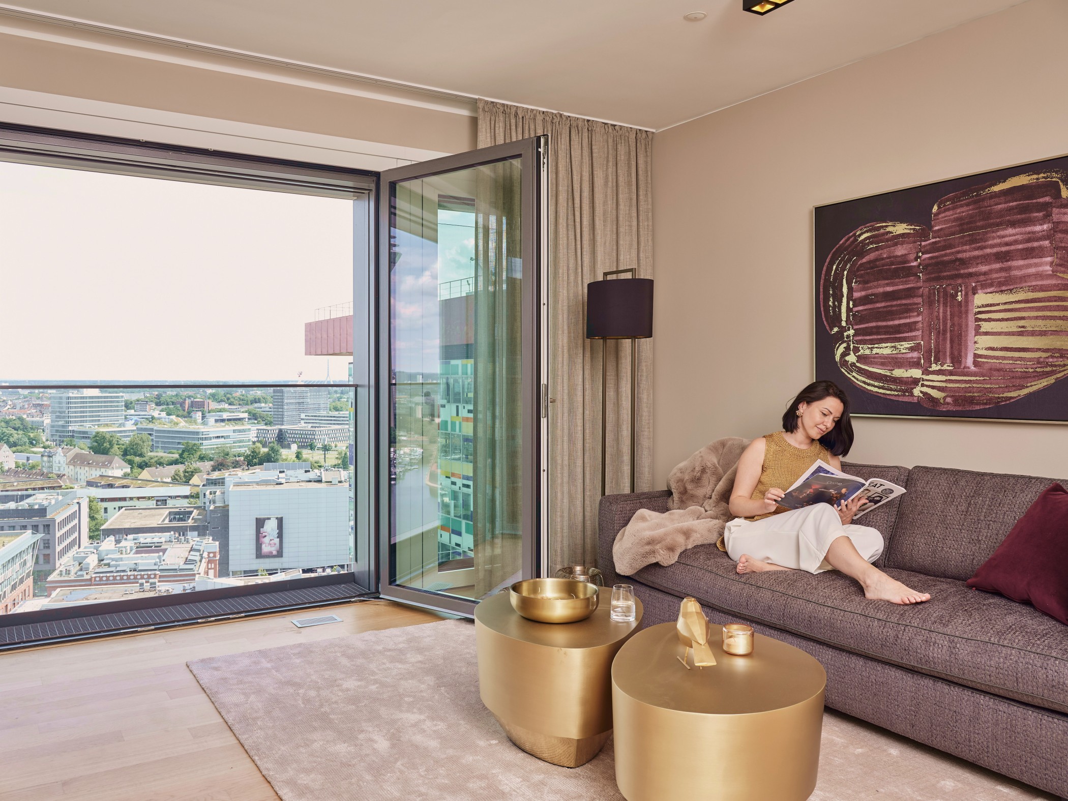 Innenansicht einer WIN WIN Wohnung im Medienhafen Düsseldorf mit weitem Stadtblick durch die geöffnete Panoramafront.