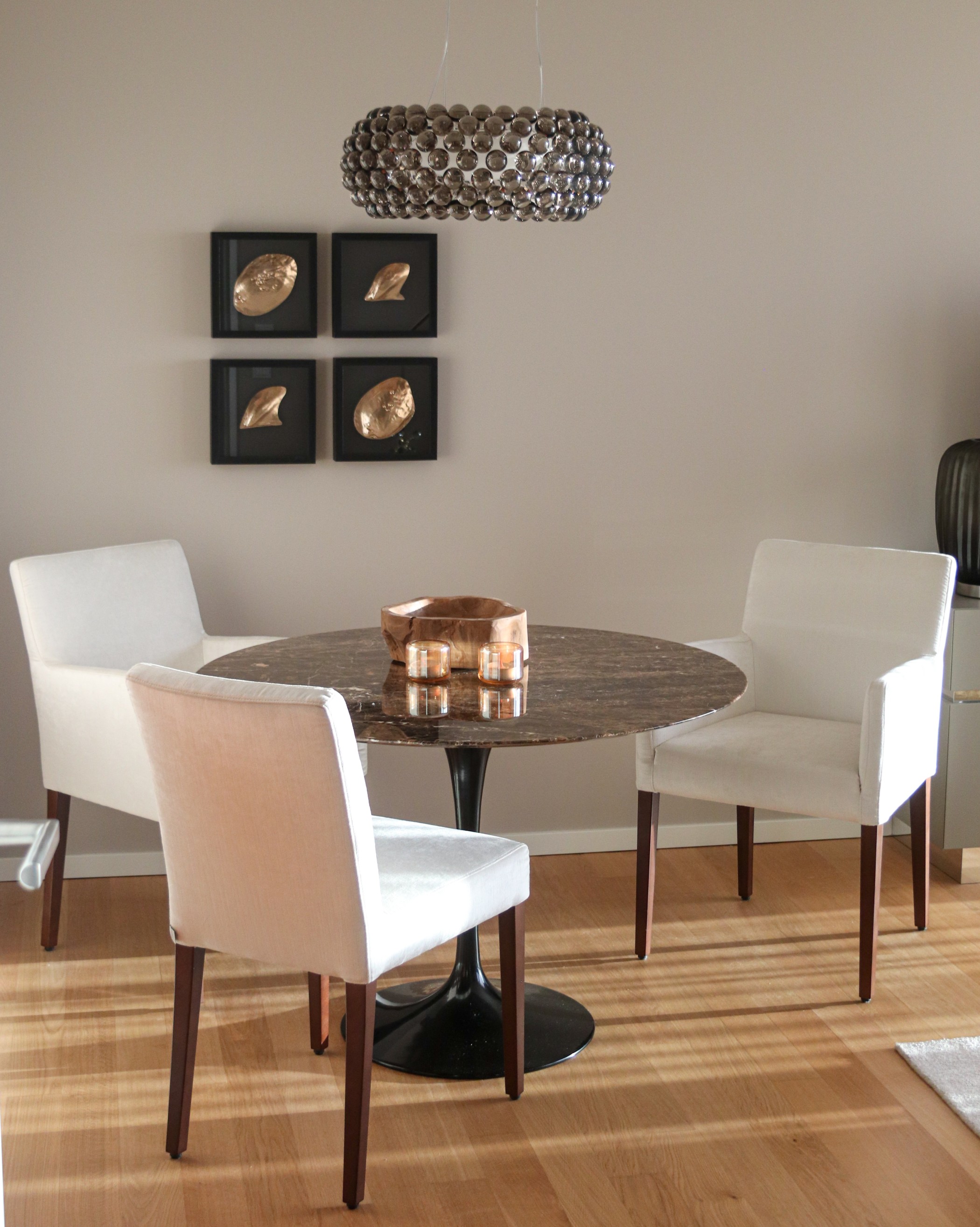 Essbereich der WIN WIN Wohnung mit rundem Marmortisch, eleganten weißen Stühlen und moderner Design-Hängelampe im Medienhafen Düsseldorf