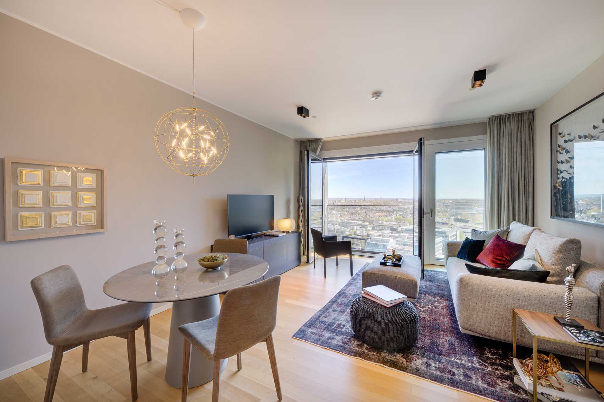 Heller Wohn- und Essbereich mit Designer-Pendelleuchte und Stadtblick – Luxuswohnung kaufen im Medienhafen Düsseldorf, Typ V (WIN WIN)