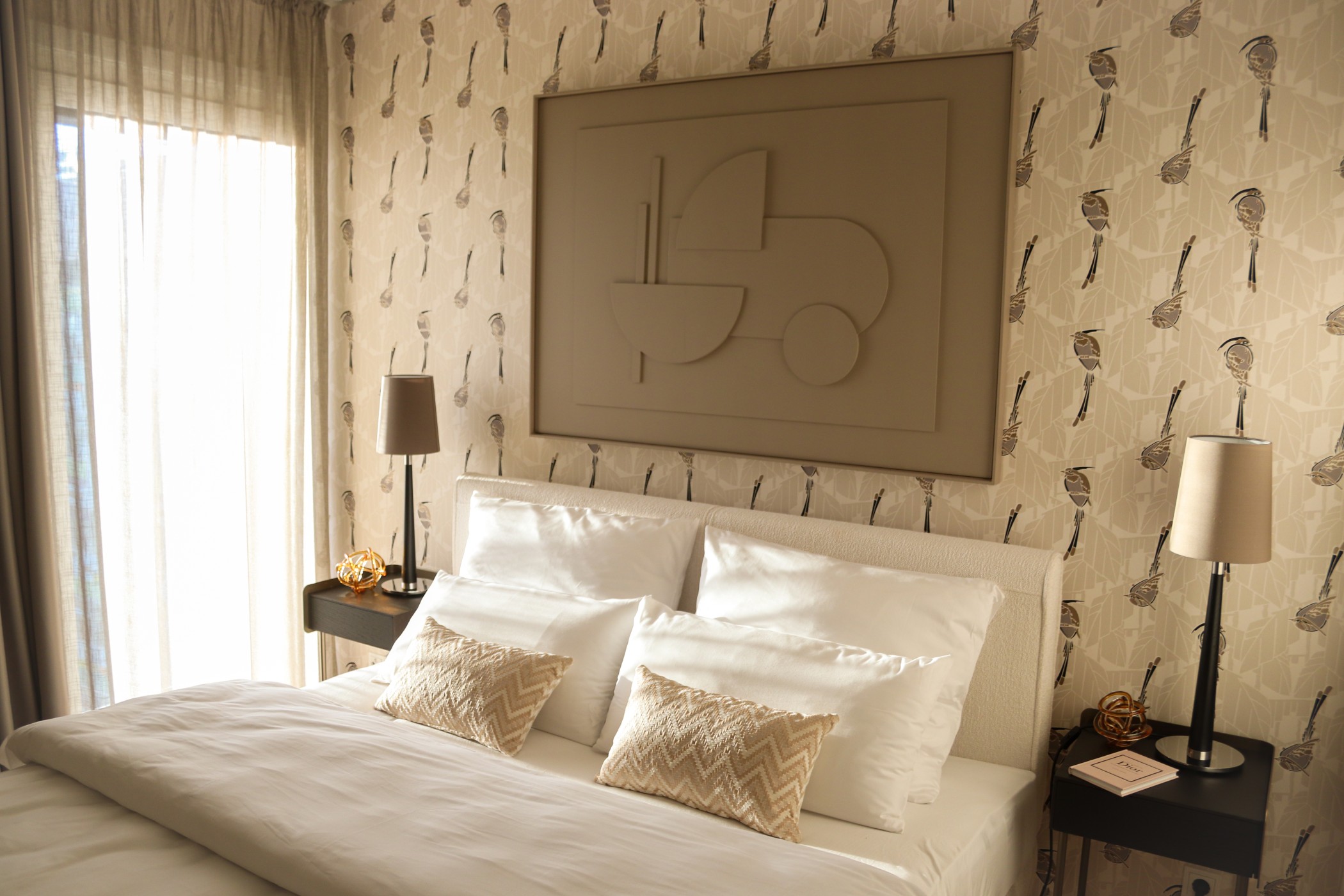 Helles Schlafzimmer mit elegantem Bett, gemusterter Tapete und stilvollen Nachttischen im WIN WIN Medienhafen Düsseldorf