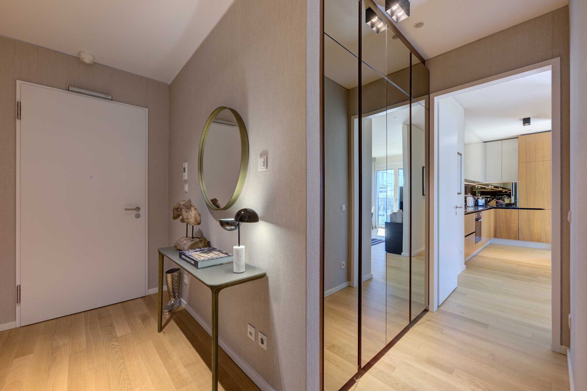 Eleganter Eingangsbereich mit Spiegelschrank und Blick in die Küche – Luxuswohnung kaufen im Medienhafen Düsseldorf, Typ U