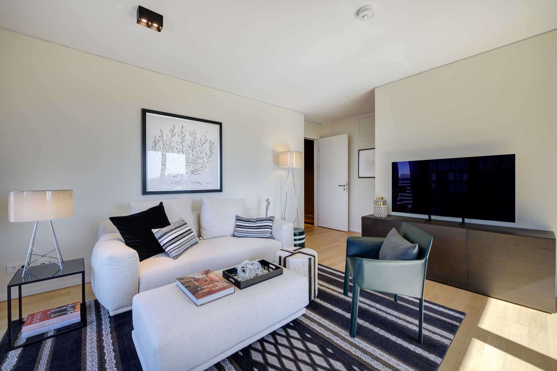 Wohnzimmer mit Sofa, Sessel und Smart-TV – Luxuswohnung kaufen im Medienhafen Düsseldorf, Typ U im WIN WIN