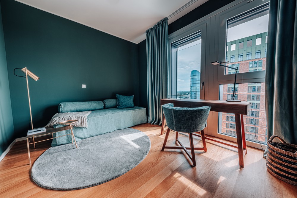 Modernes Wohnzimmer mit Arbeitsbereich und weitem Ausblick über den Medienhafen in Düsseldorf im WIN WIN