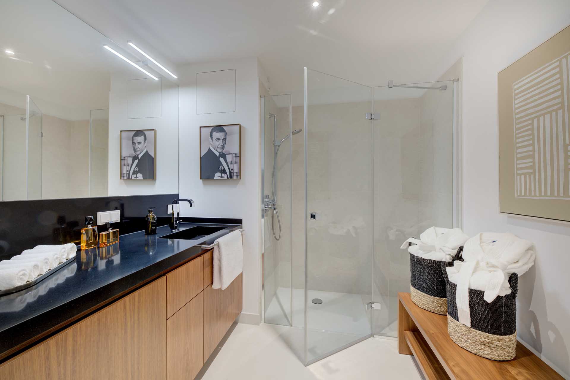 Modernes Badezimmer mit Dusche, schwarzer Waschtischplatte und Walnussmöbeln – Luxuswohnung Typ V im Medienhafen Düsseldorf kaufen