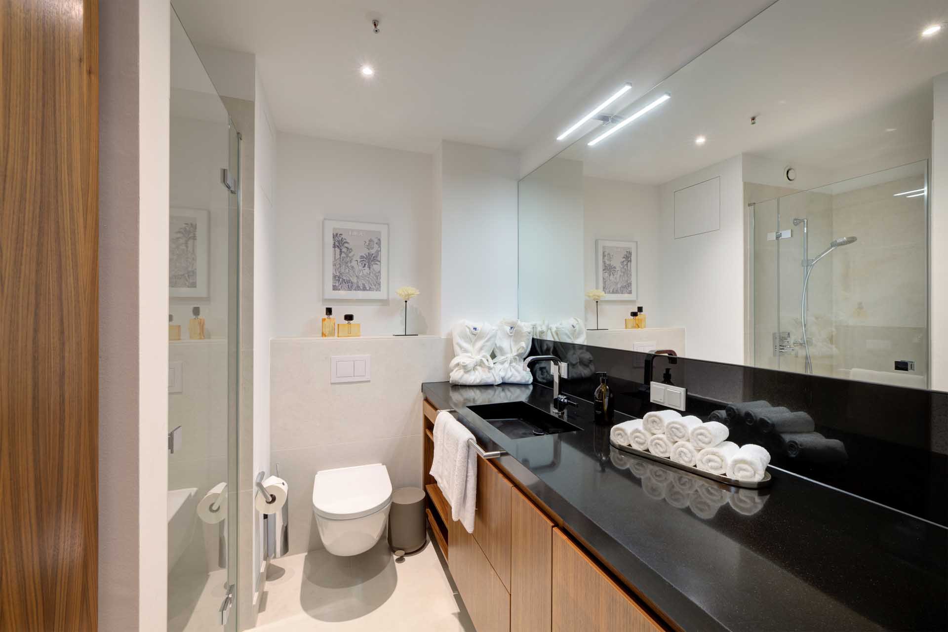 Modernes Badezimmer mit Dusche und schwarzer Waschtischplatte – Luxuswohnung Typ T im Medienhafen Düsseldorf kaufen