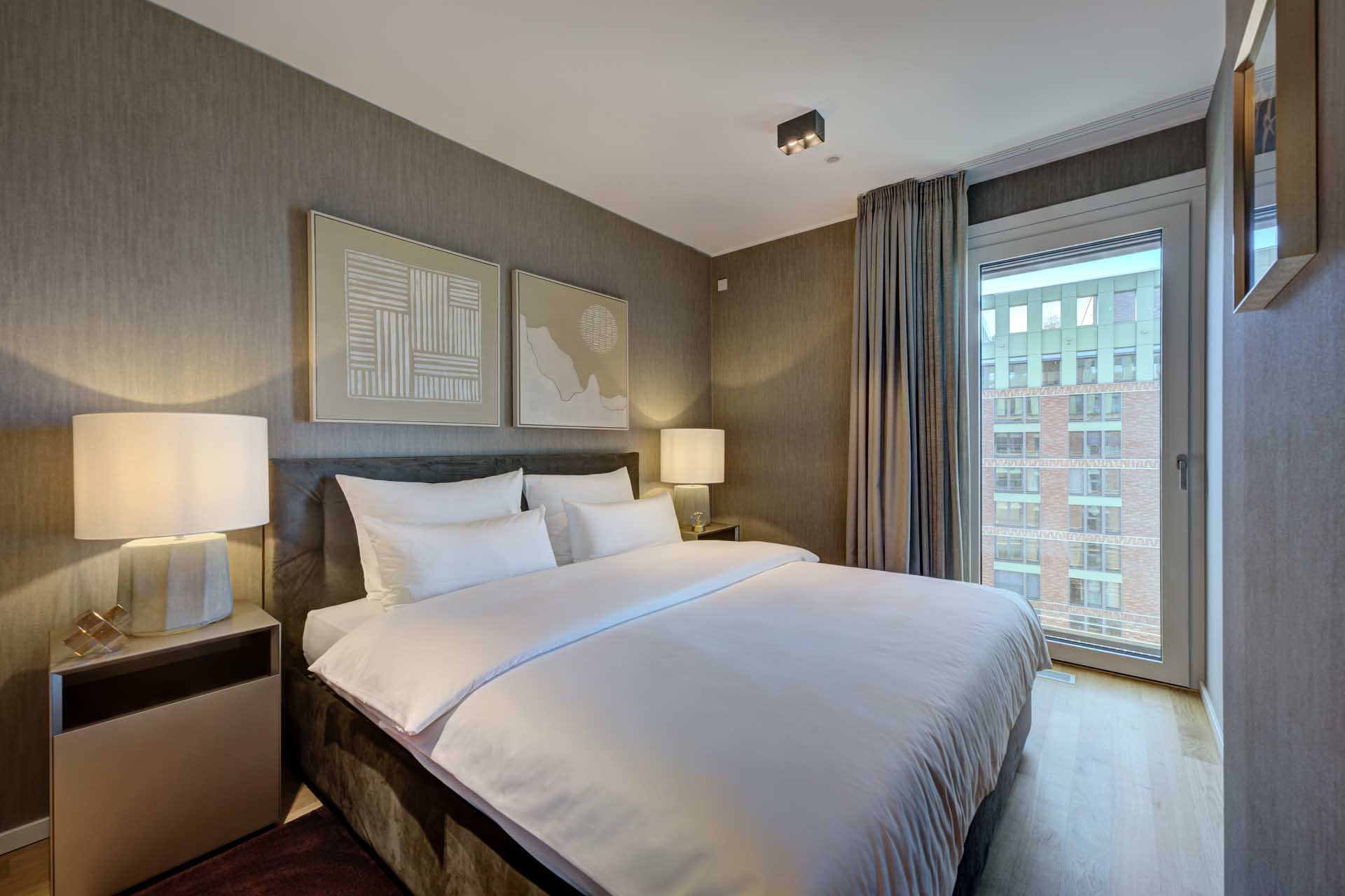 Schlafzimmer mit Doppelbett und Fenster zum Hafenviertel – Luxuswohnung kaufen im Medienhafen Düsseldorf, Typ U