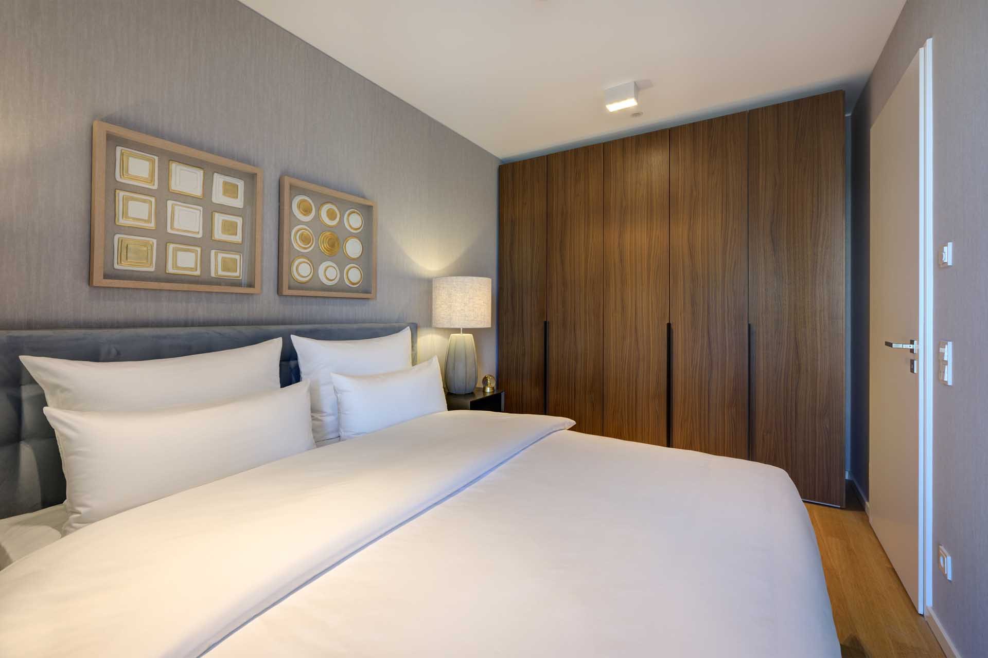 Schlafzimmer mit großem Walnuss-Einbauschrank – Luxuswohnung kaufen im Medienhafen Düsseldorf, Typ T