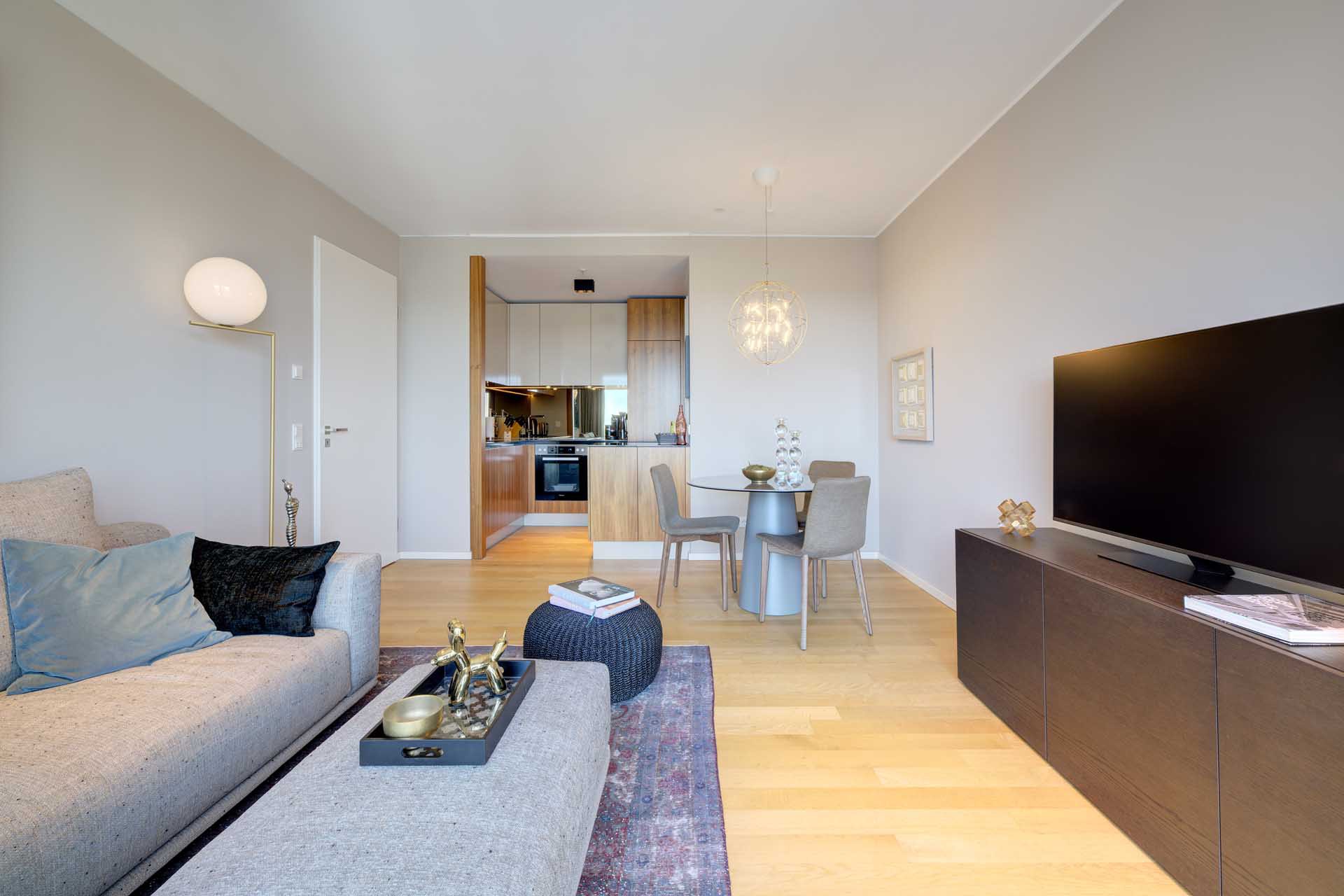 Wohnzimmer mit Smart-TV, Essbereich und offener Küche – Luxuswohnung kaufen im Medienhafen Düsseldorf, Typ V