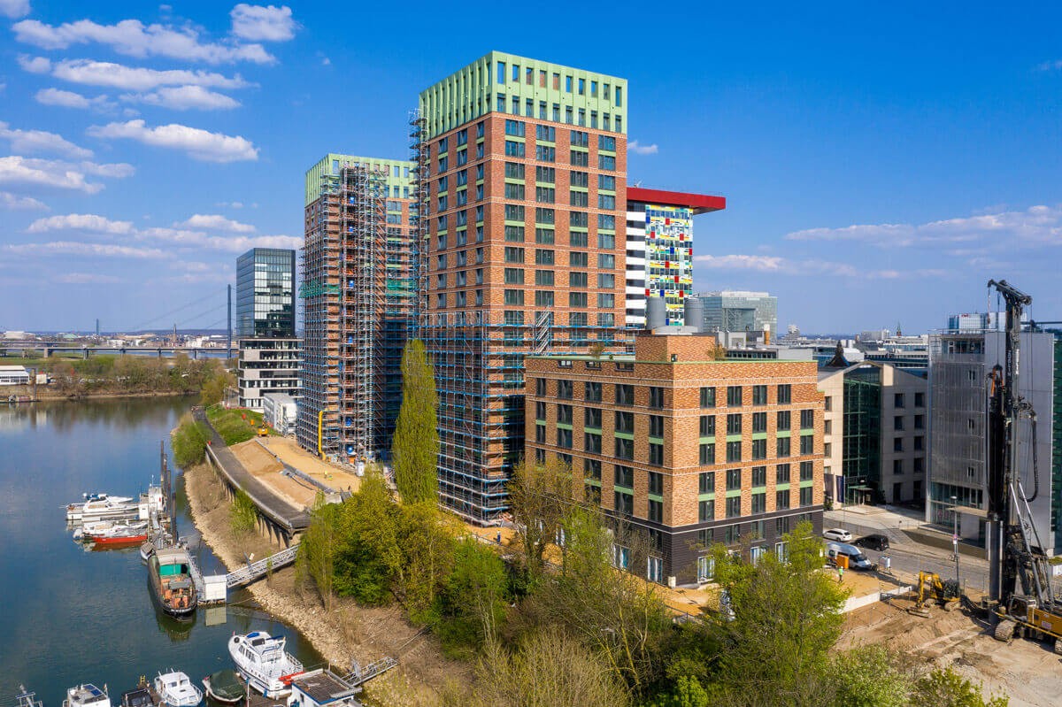 Luftaufnahme des WIN-WIN Hochhausensembles im Düsseldorfer Medienhafen während der Bauphase mit Blick auf den Hafen, umliegende Architektur und Wasserlage