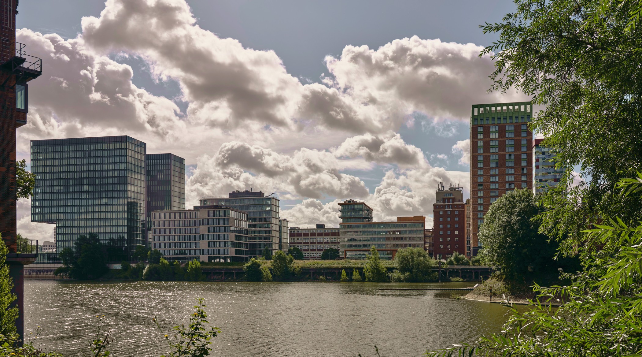 Panorama des Medienhafens Düsseldorf mit moderner Skyline und den WIN WIN Türmen am rechten Bildrand, gesehen vom Hafenbecken aus.
